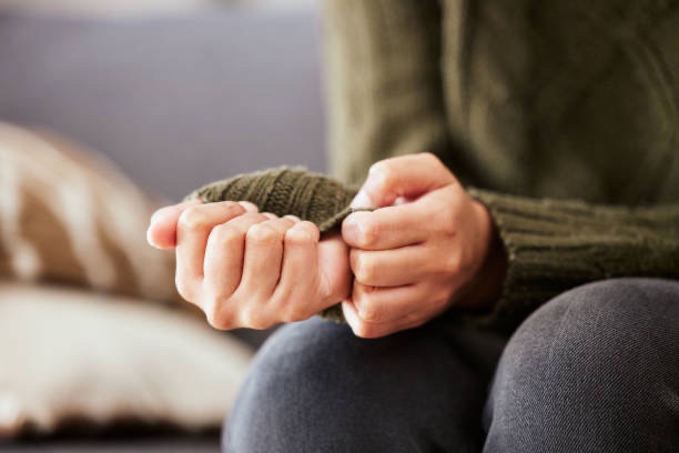 Person sitting quietly holding their own hands, illustrating anxiety and stress counseling in Longwood FL